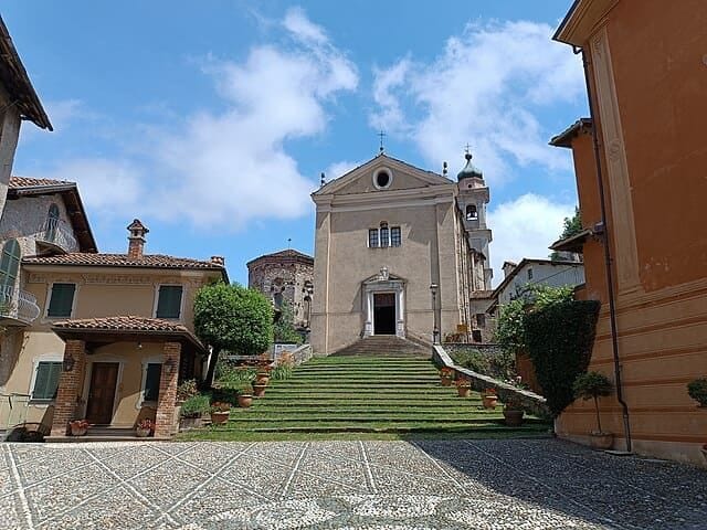 Garessio: facciata barocca in pietra chiara e campanile slanciato con le Alpi Marittime a fare da cornice.
