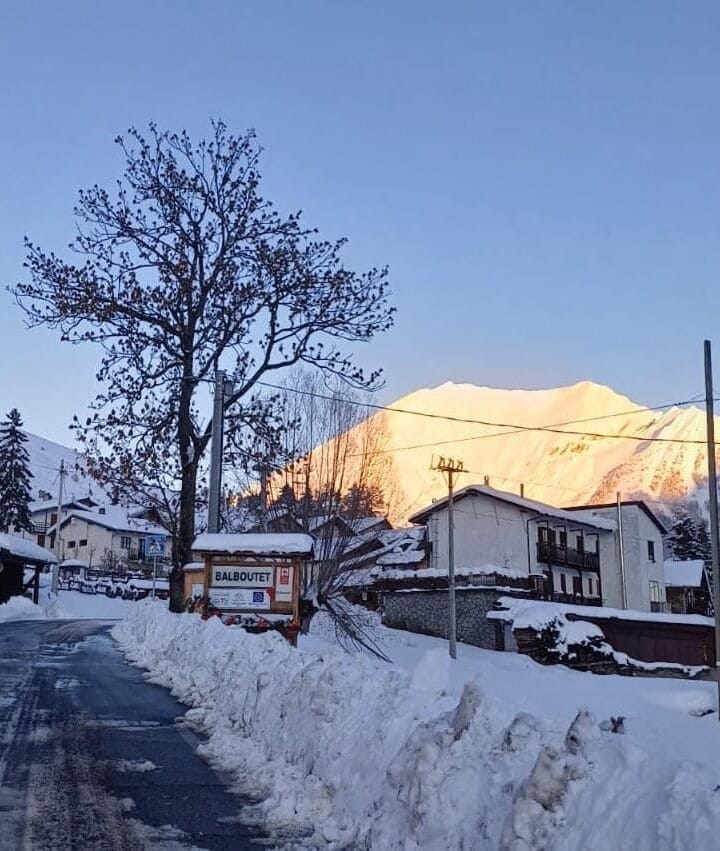 Scorcio panoramico del borgo alpino di Balboutet in Val Chisone, Piemonte, con case in pietra e tetti in lose.