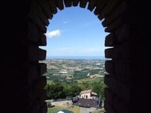 Veduta aerea della maestosa Rocca Malatestiana di Montefiore Conca che domina la valle al tramonto.