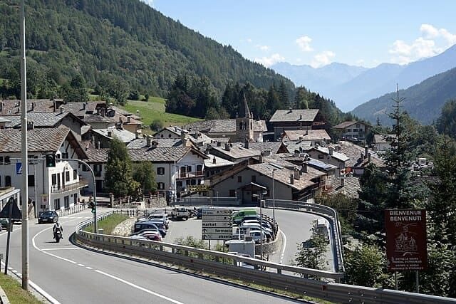 Veduta panoramica del borgo di Étroubles circondato dalle montagne della Valle d'Aosta in estate.