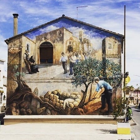 San Sperate, Paese Museo: murale su casa in ladiri che ritrae la vita contadina nel cuore del centro storico sardo.