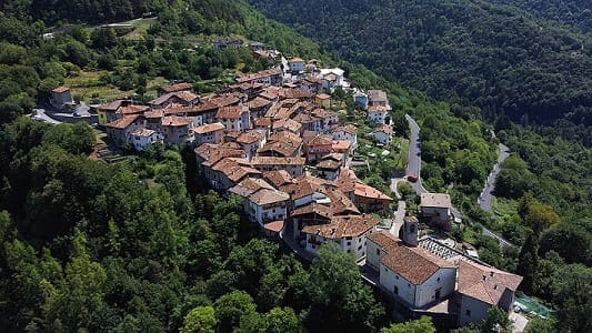 Fotografia paesaggistica del centro storico di Bondone in Trentino, con le case in pietra caratteristiche e il panorama alpino circostante.