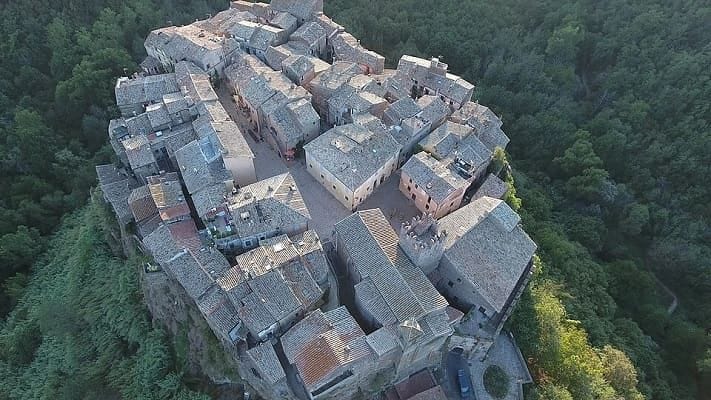 Veduta aerea del borgo medievale di Calcata Vecchia sospeso sulla rupe di tufo.
