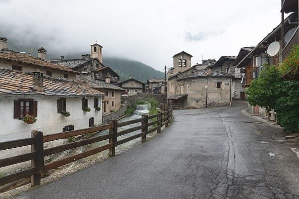 Veduta panoramica del torrente Varaita che attraversa il borgo in pietra di Chianale in estate