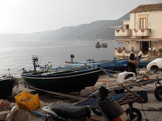 Vicolo stretto in pietra a Chianalea di Scilla che scende direttamente nel mare blu.
