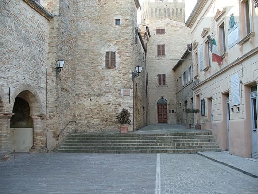 Vista di Piazza Castello a Moresco nelle Marche, con l'elegante portico medievale e la pianta ellittica del borgo.